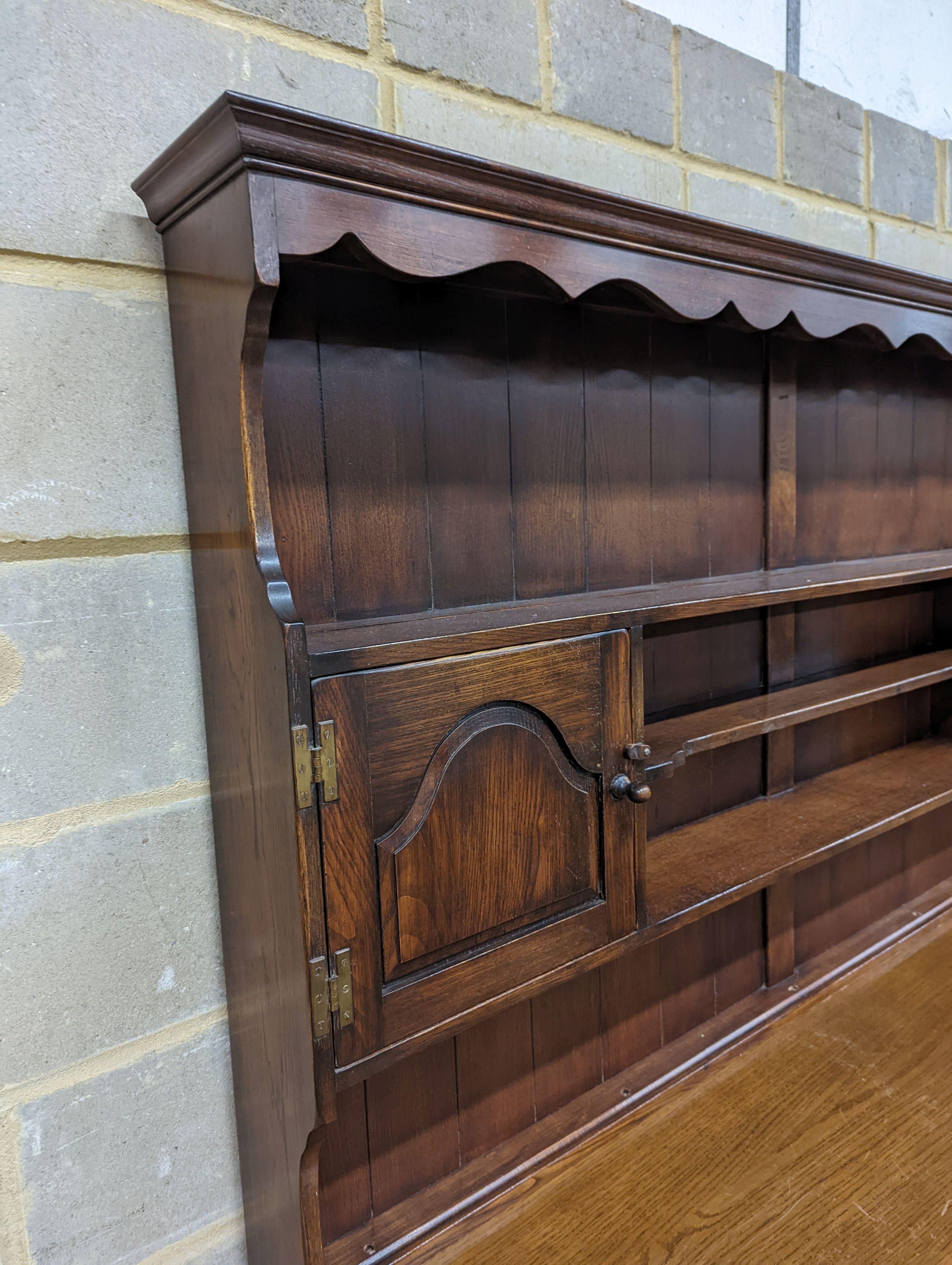 A Georgian style oak dresser base with boarded rack, W-184cm, D-46cm, H-188cm.